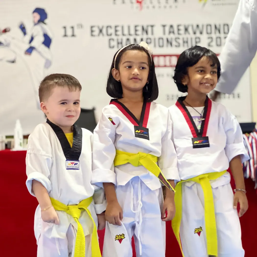 طلاب صغار من Excellent Taekwondo بالزي الرسمي في بطولة